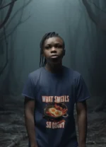 A young boy wearing a soft "What Smells So Good?" t-shirt, smiling and looking carefree.