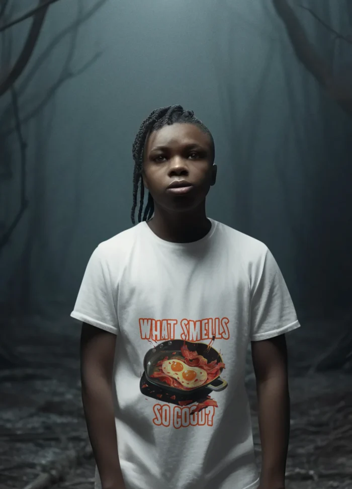 A young boy wearing a soft "What Smells So Good?" t-shirt, smiling and looking carefree.