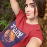 Girl wearing Jurassic Park: Let's Have a Walk t-shirt with dinosaur graphic.