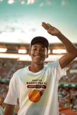 Boy wearing a blue practice basketball t-shirt, dribbling a basketball on an outdoor court.