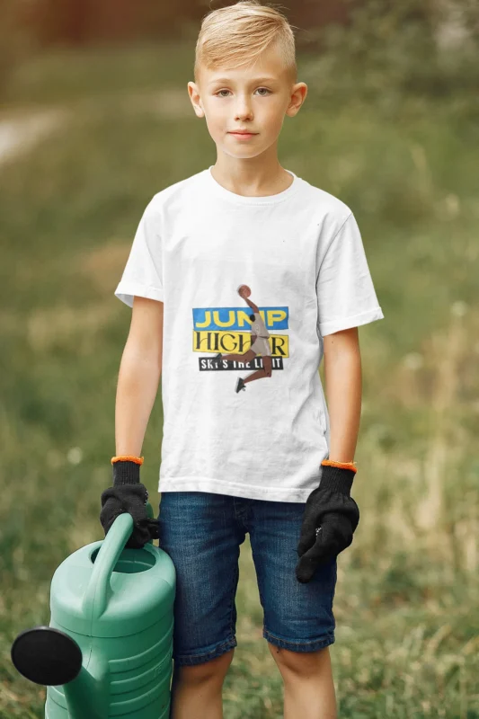 A young boy wearing the NBA "Jump Higher, Sky Is the Limit" t-shirt, leaping with a basketball under a vibrant sky, symbolizing determination and ambition.